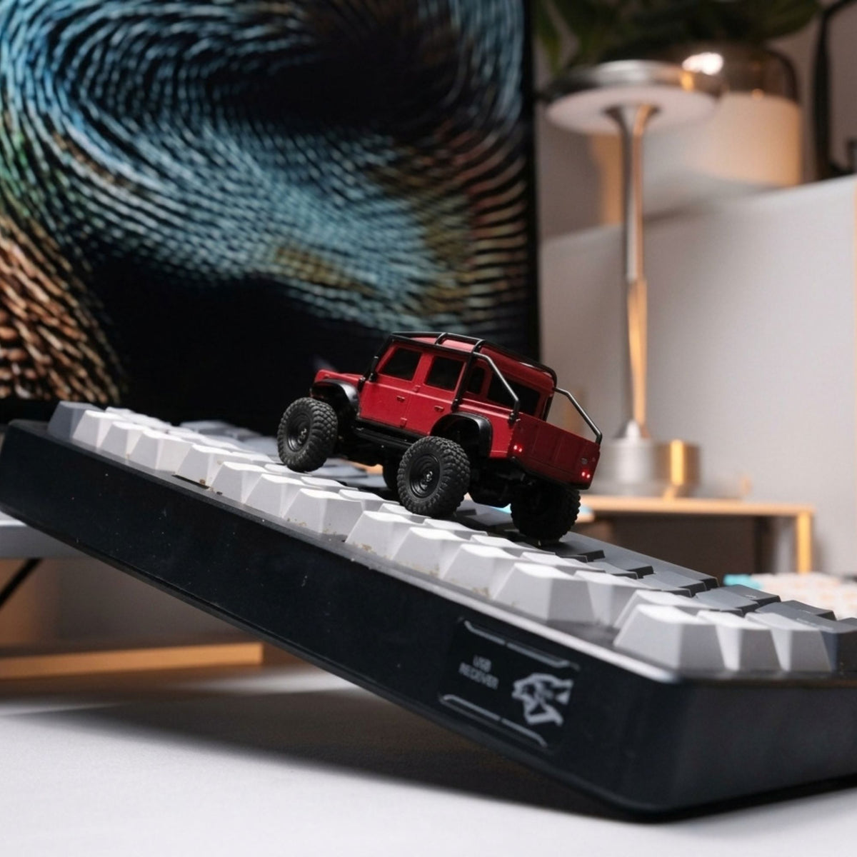 Red 1:43 Land Rover Defender 110 RC Crawler on keyboard