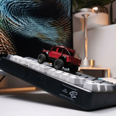Red 1:43 Land Rover Defender 110 RC Crawler on keyboard