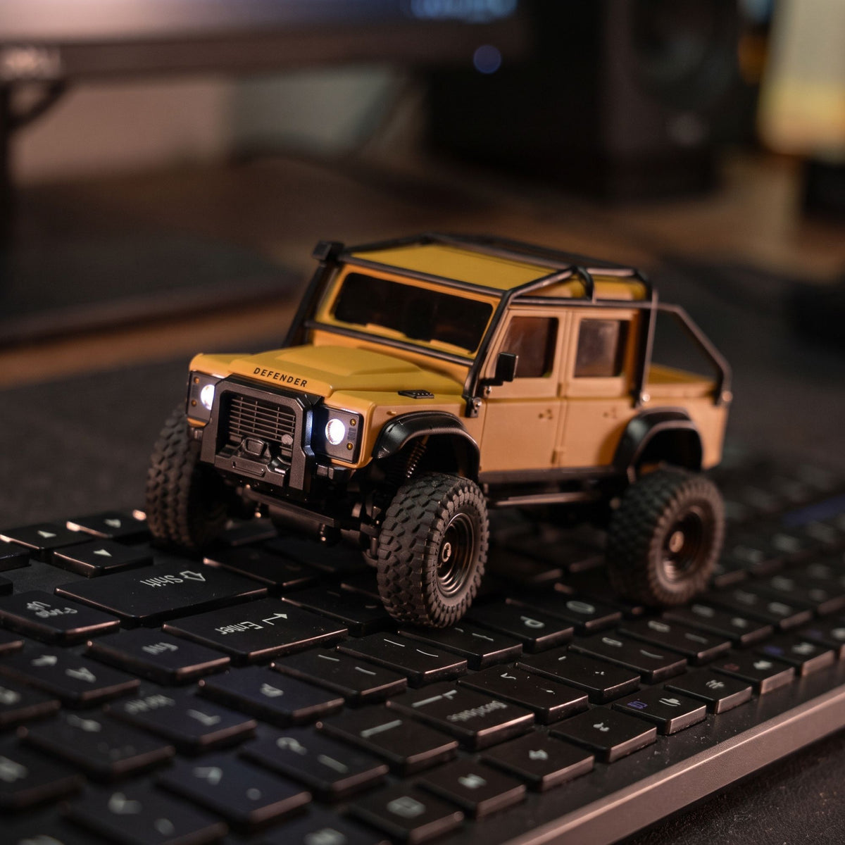yellow 1:43 Land Rover Defender 110 RC Crawler on keyboard